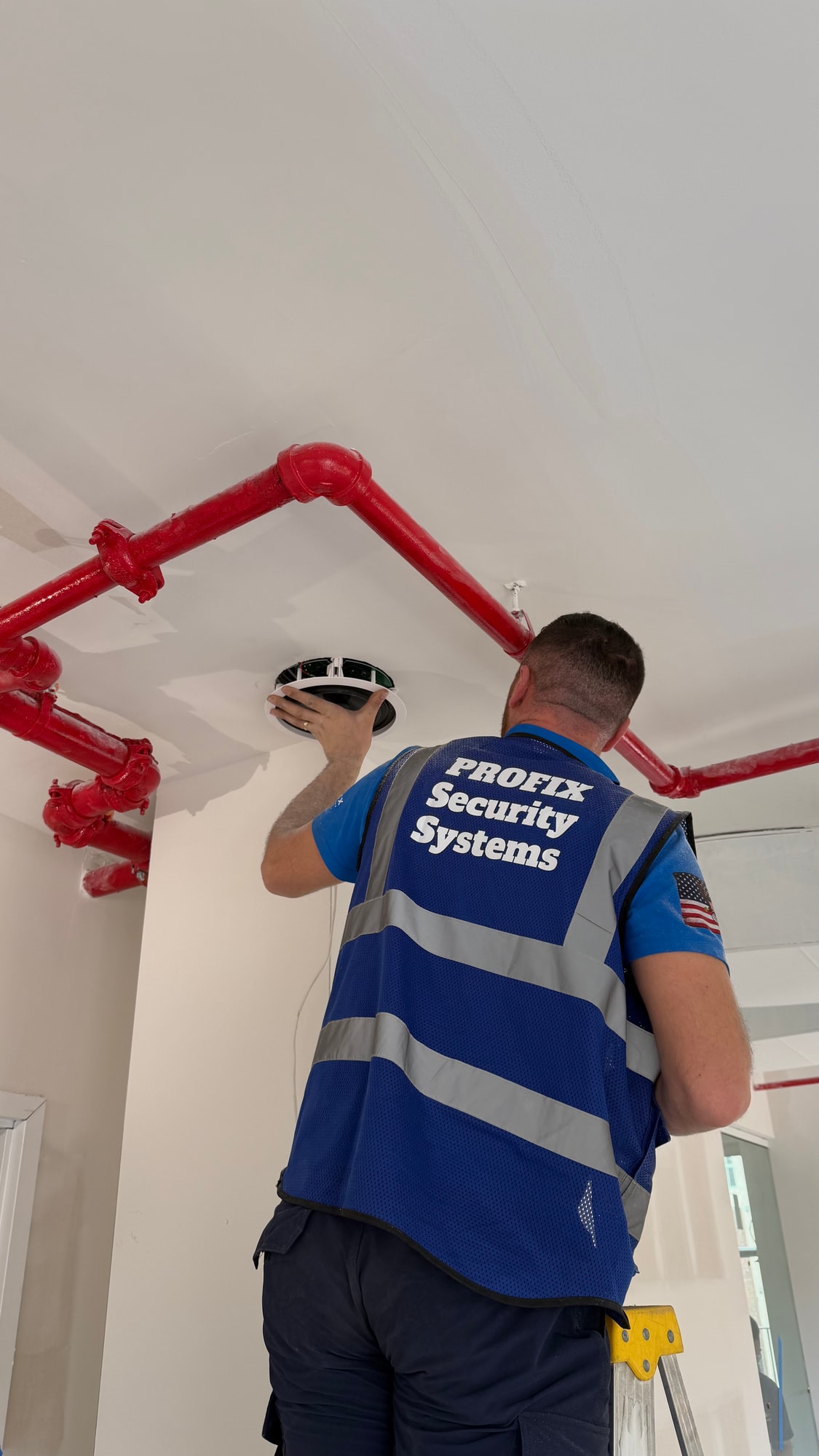 Profix Security Systems technician installing a ceiling-mounted surveillance camera in New Jersey.