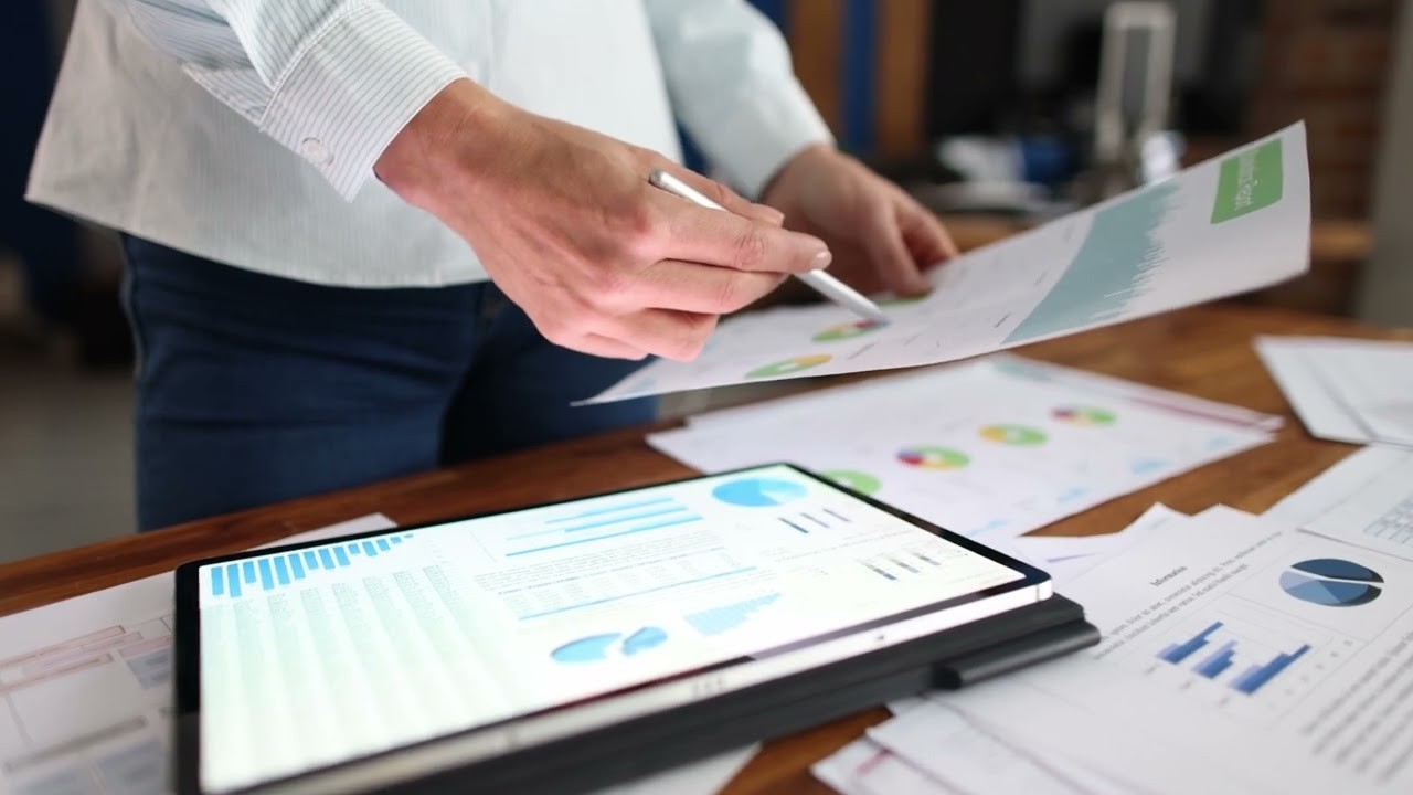 Business woman working with tablet computer and financial charts in office