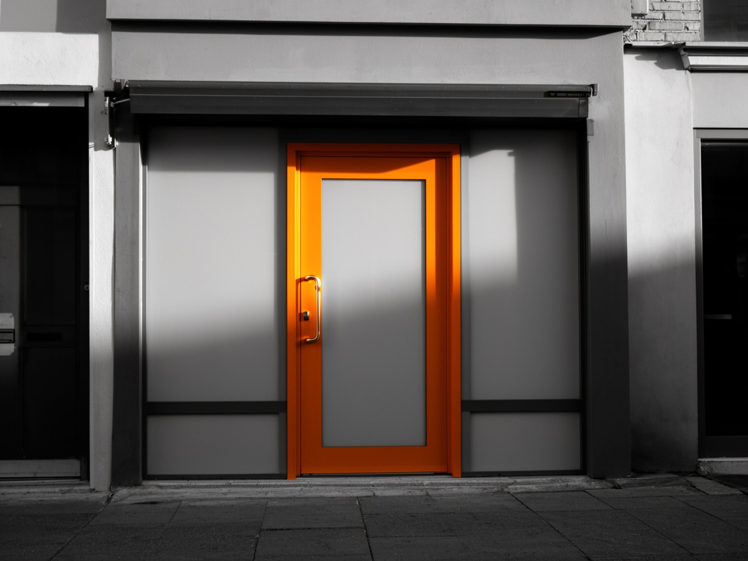 Small business storefront with sunrise amber door handle highlighted in selective color black and white photo